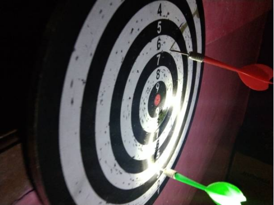Ambidextrous dart training method, practicing with both hands on a dart board.