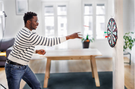 "Close-up of elbow angle during dart throw for better accuracy.