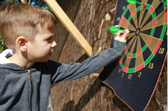 Kids playing group dart game to enhance social skills.