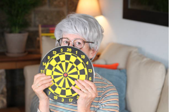 senior using dart board for hand eye coordination training