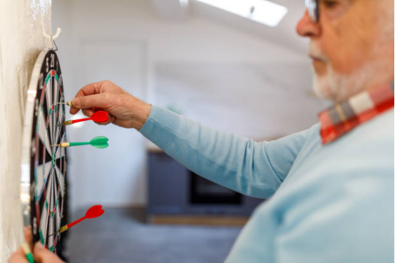 senior using dart board for hand eye coordination training