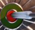 Dart hitting the red bullseye of a modern dart board.