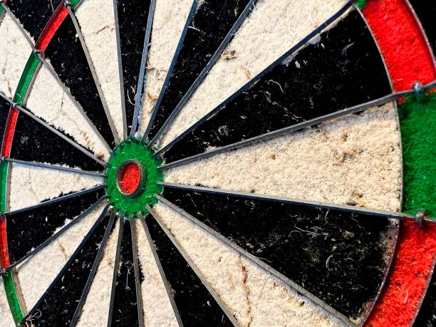 Angled close-up of a used bristle dart board, showing texture and red, green segments.